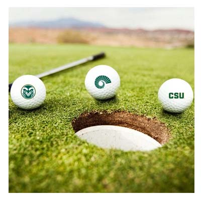 Three CSU Rams golf balls sit on a putting green